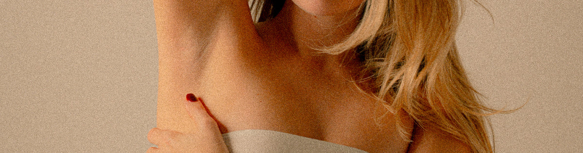 Frau mit erhobenem Arm und glatter Achsel als Motiv für professionelles Achsel-Waxing bei migo in Hannover.